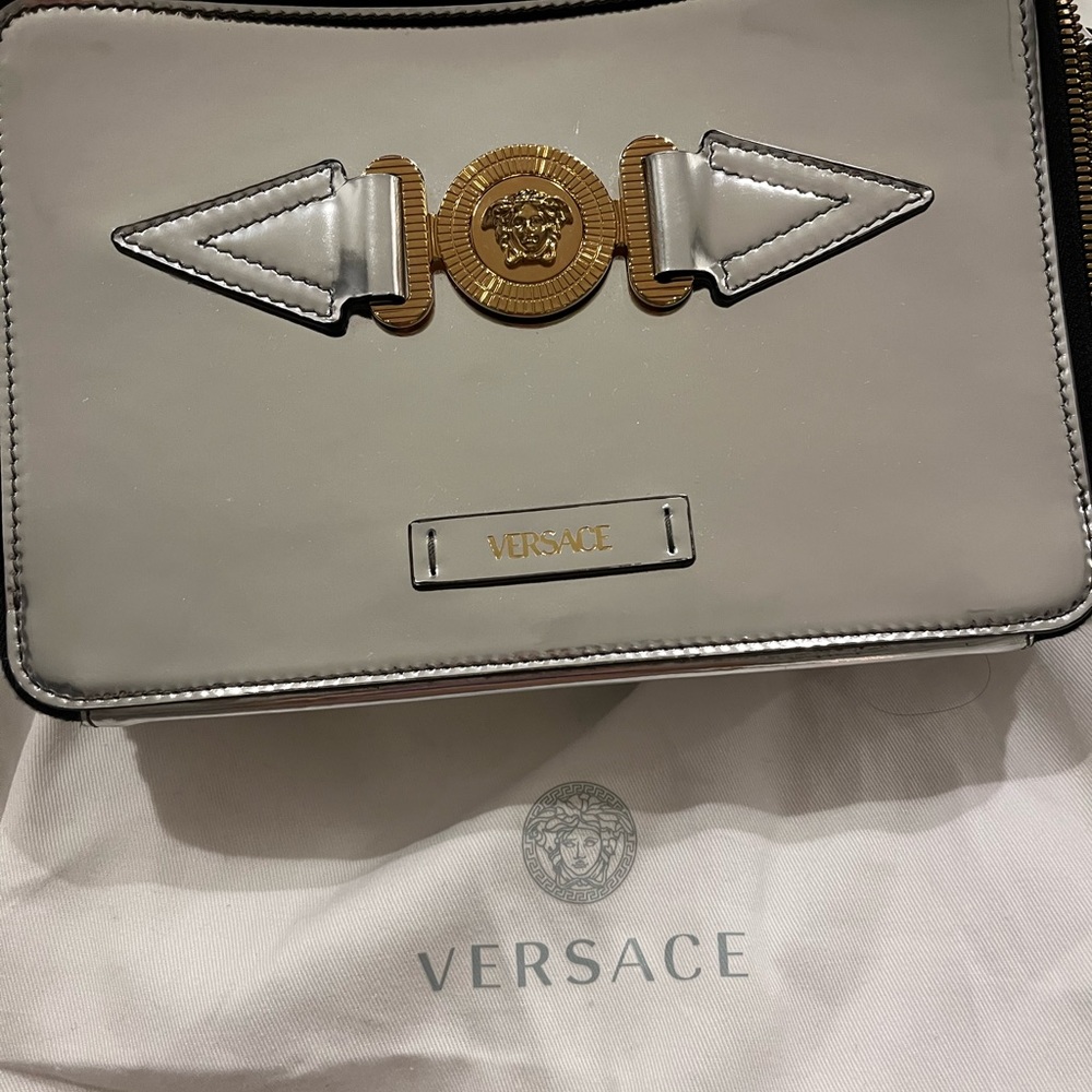 The silver messenger bag for men and women by Versace.  Brand new.